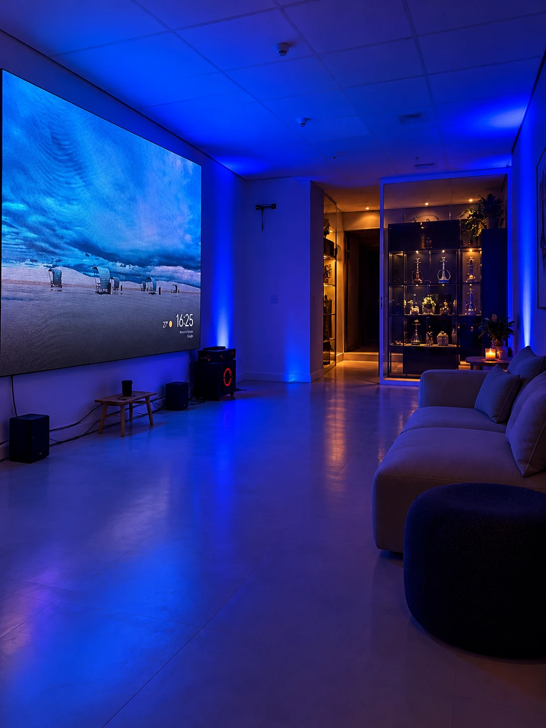 Lounge com telão de LED, sofá e vitrine iluminada